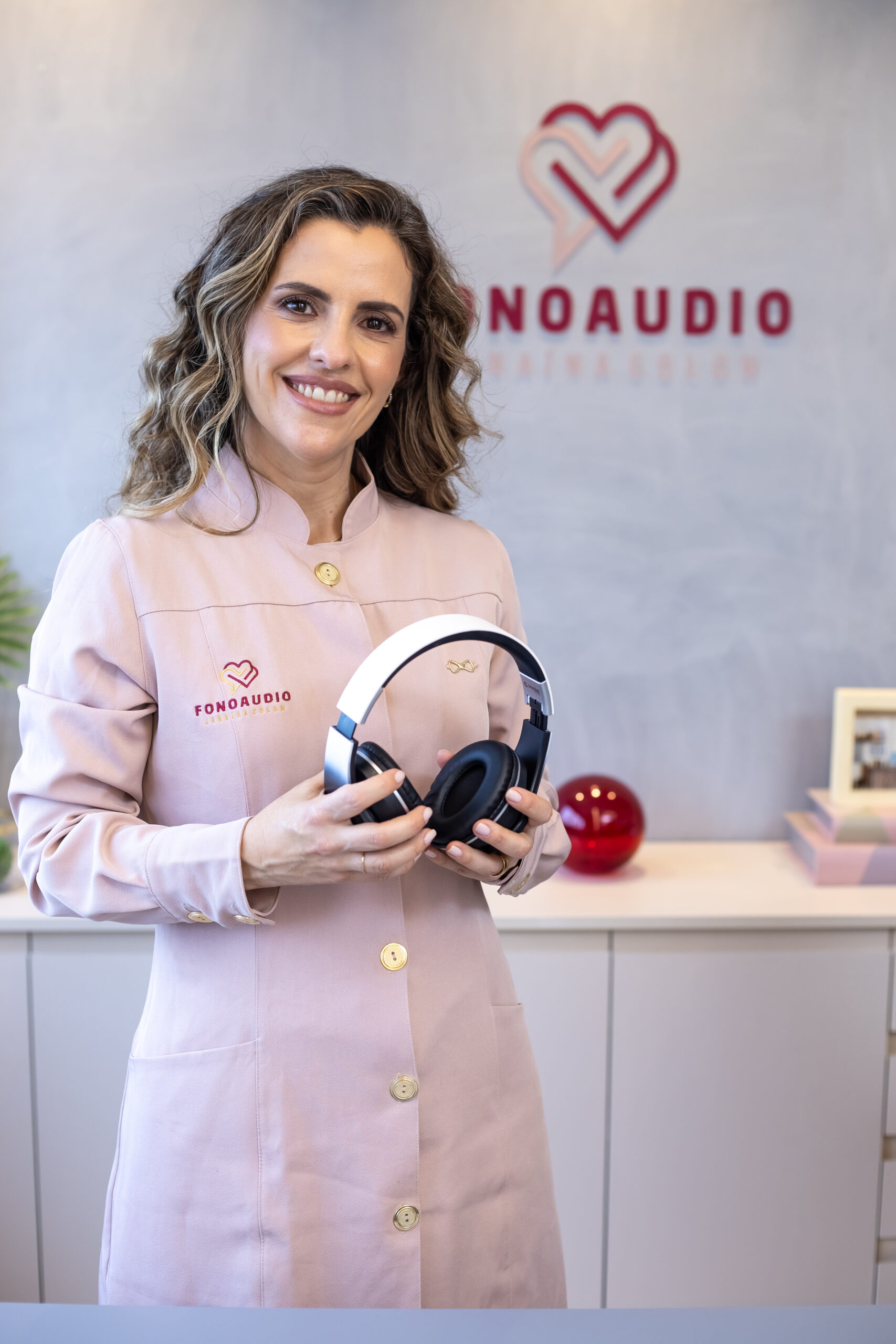 Dra. Janaína Colon, audiologista em Indaiatuba, segurando um fone de audiometria